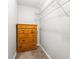 This walk-in closet features a wooden dresser, white shelving, and neutral carpet at 5745 River Ridge Ln, Sugar Hill, GA 30518