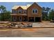 Unfinished two-story home featuring a two-car garage and a yard with construction materials at 1587 Sungrown Way, Mcdonough, GA 30253