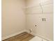 Bright laundry room with a wire shelf and wood-look vinyl flooring at 1587 Sungrown Way, Mcdonough, GA 30253