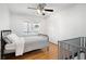 Cozy bedroom with hardwood floors, a queen-sized bed, and a crib at 244 Sherbrook Nw Ct, Marietta, GA 30064