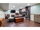 Finished basement living room boasts a stone fireplace, custom bookshelves, and dark wood flooring at 244 Sherbrook Nw Ct, Marietta, GA 30064