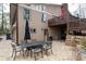 Rear exterior view showing the stone patio and backyard with upper deck and outdoor seating area at 244 Sherbrook Nw Ct, Marietta, GA 30064