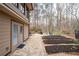 Rear exterior view showing a stone patio with furniture, landscaping, and access to the home's interior at 244 Sherbrook Nw Ct, Marietta, GA 30064