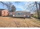 View of the back of the house with a large backyard, small deck and partial fence at 2716 Wedgewood Ter, Decatur, GA 30032