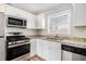 Modern kitchen with stainless steel appliances, granite countertops, and white cabinetry at 2716 Wedgewood Ter, Decatur, GA 30032