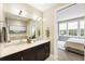 Elegant bathroom with double sinks, modern lighting, and a view into the bedroom through an open doorway at 58 Canton St # 302, Alpharetta, GA 30009