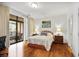 Comfortable bedroom with hardwood floors and a glass door leading to a private balcony at 3286 Northside Nw Pkwy # 304, Atlanta, GA 30327