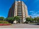 A modern building with balconies is framed by a colorful flower bed in the foreground at 3286 Northside Nw Pkwy # 304, Atlanta, GA 30327