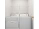 A laundry room with white appliances and a wire rack, for convenient storage and organization at 3600 Elkhorn Nw Ct, Duluth, GA 30096