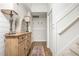 Inviting hallway with wood floors, wainscoting, and a decorative cabinet with lamps at 3975 River Club Dr, Cumming, GA 30041