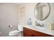 Bathroom featuring a decorative mirror, framed art, and a cherry vanity with white sink and toilet at 4349 Highborne Ne Dr, Marietta, GA 30066