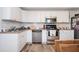 Kitchen with white cabinets, stainless steel appliances, tile backsplash, and laminate floors at 4349 Highborne Ne Dr, Marietta, GA 30066