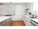 Well-lit kitchen featuring white cabinets, wooden shelving, stainless steel appliances, and a sink under an arched window at 4349 Highborne Ne Dr, Marietta, GA 30066
