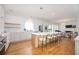 Open-concept kitchen with white cabinets, hardwood floors, stainless steel appliances, island seating, and connected living room at 4349 Highborne Ne Dr, Marietta, GA 30066