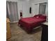 Well-lit bedroom with a red plaid bedspread and laminate flooring at 4906 Kellys Mill Nw Dr, Lilburn, GA 30047