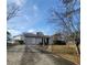 Cozy home exterior with long driveway and well-maintained lawn under a beautiful sky at 4906 Kellys Mill Nw Dr, Lilburn, GA 30047