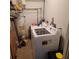 Functional laundry room featuring a washing machine, dryer, and water heater with storage at 4906 Kellys Mill Nw Dr, Lilburn, GA 30047