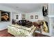 Inviting living room features a fireplace, hardwood floors, floral sofa, and large comfortable seating at 1923 Rugby Ave, Atlanta, GA 30337
