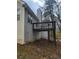 Backyard view featuring an elevated deck with stairs, adjacent to the home's light siding at 2071 Boone Pl, Snellville, GA 30078