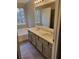 Bathroom features double sink vanity, large mirror, tub and shower with natural light at 2071 Boone Pl, Snellville, GA 30078