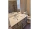 Bathroom with neutral wall paint, white countertops, grey cabinets, tile walls and new toilet at 2071 Boone Pl, Snellville, GA 30078