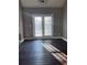 Living area with hardwood floors, ample natural light from the French doors and a modern ceiling fan at 4415 Yates Rd, Atlanta, GA 30337