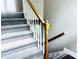 Staircase featuring carpeted steps, white spindles, and a wood handrail at 4415 Yates Rd, Atlanta, GA 30337