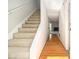 Hallway featuring a staircase with carpeted steps and a hardwood floor that leads to the front door at 6437 Stone Way, Morrow, GA 30260