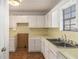Kitchen with white cabinets and countertops that need updates at 6437 Stone Way, Morrow, GA 30260