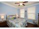Cozy bedroom with a blue accent wall, hardwood floors and a ceiling fan at 505 Appalachian Woods Dr, Canton, GA 30114