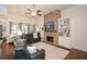 Cozy living room with stone fireplace, hardwood floors, built-in shelves, and a ceiling fan at 505 Appalachian Woods Dr, Canton, GA 30114