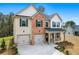 Attractive two-story home with a brick facade, double garage, and manicured landscaping at 1645 Fuma Leaf Way, Mcdonough, GA 30253