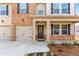 Welcoming entryway with double garage, a charming front door, and manicured landscaping at 1645 Fuma Leaf Way, Mcdonough, GA 30253