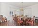 Open-concept dining room with hardwood floors, classic chandelier, and antique furniture at 3130 Caney Creek Ln, Cumming, GA 30041