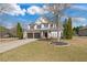 Charming two-story home featuring a stone facade, black garage doors, and well-maintained landscaping on a sunny day at 3130 Caney Creek Ln, Cumming, GA 30041