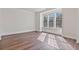 Bright room featuring hardwood floors, three windows bringing in light, and white walls and trim at 3130 Caney Creek Ln, Cumming, GA 30041