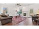 Living room featuring a cozy fireplace, hardwood floors, a ceiling fan, and a view to the backyard at 3130 Caney Creek Ln, Cumming, GA 30041