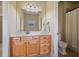 Well-lit bathroom with wood vanity and tile flooring and a shower with curtain rod at 13029 Dartmore Ave, Alpharetta, GA 30005