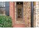 Elegant stone-clad entryway featuring a brick walkway and a glimpse into the home's interior at 13029 Dartmore Ave, Alpharetta, GA 30005