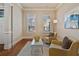 Cozy living room featuring neutral walls, hardwood floors, and two sunny windows with white shutters at 13029 Dartmore Ave, Alpharetta, GA 30005