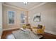 Bright living room with neutral walls, hardwood floors, and a view of the neighborhood through white-shuttered windows at 13029 Dartmore Ave, Alpharetta, GA 30005