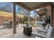 Covered patio boasts a dining set, swing, and a cozy fire pit, perfect for outdoor gatherings at 13029 Dartmore Ave, Alpharetta, GA 30005