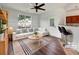 Bright, staged living room features a white sectional couch, wood floors, and a view to the outside at 2399 Coach Way, Jonesboro, GA 30236