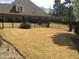 Spacious backyard with brick home, black metal fence and mature plantings at 2392 Ivy Mountain Dr, Snellville, GA 30078