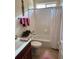 Bright bathroom featuring a tub with white tile surround, single sink vanity, and decorative accents at 2392 Ivy Mountain Dr, Snellville, GA 30078