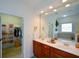 Bathroom with double sinks, cherry cabinets, and walk-in closet at 2392 Ivy Mountain Dr, Snellville, GA 30078