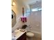 Bright bathroom featuring a tub with white tile surround, single sink vanity, and decorative accents at 2392 Ivy Mountain Dr, Snellville, GA 30078