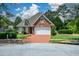Beautiful brick home with an attached garage and a brick driveway, nestled within a green, landscaped yard at 2392 Ivy Mountain Dr, Snellville, GA 30078