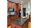 Stylish kitchen island with a granite countertop, cherry wood cabinetry, and stainless appliances at 2392 Ivy Mountain Dr, Snellville, GA 30078