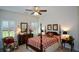 Traditional main bedroom featuring a four-poster bed, ceiling fan, and bright natural light from shuttered windows at 2392 Ivy Mountain Dr, Snellville, GA 30078